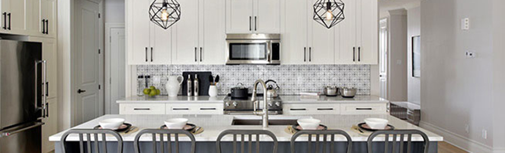 Neutral coloured kitchen with a dark grey island and white cabinets